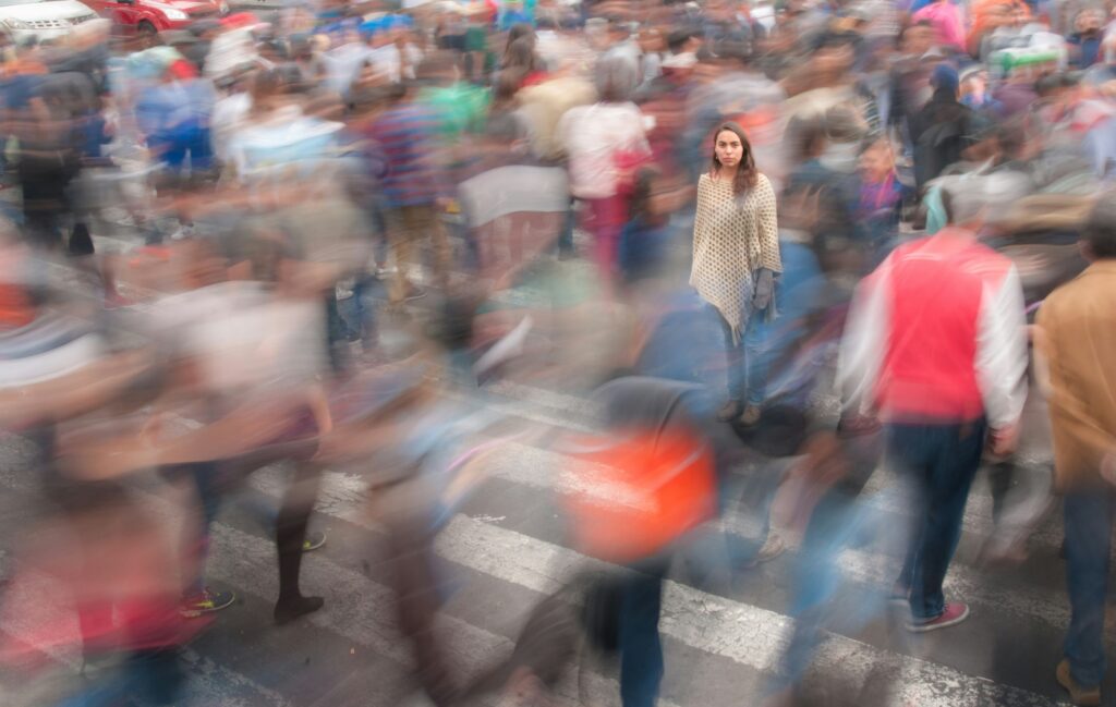 Woman standing still in a moving crowd