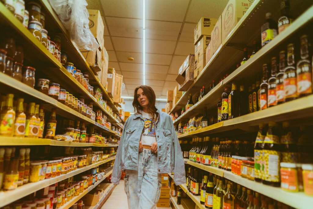 Woman choosing between products in a supermarket aisle